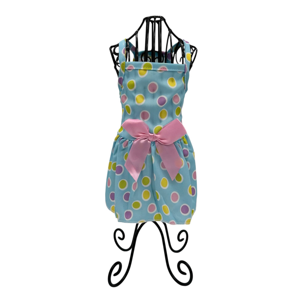 Polka dot cat dress with a pink bow on a black stand against a white background