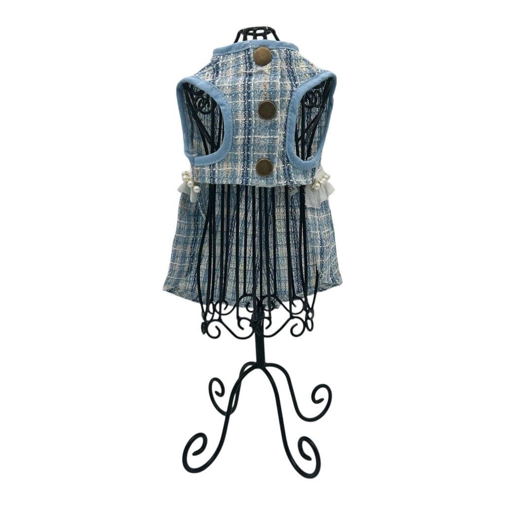 Blue plaid cat dress on a decorative stand against a white background