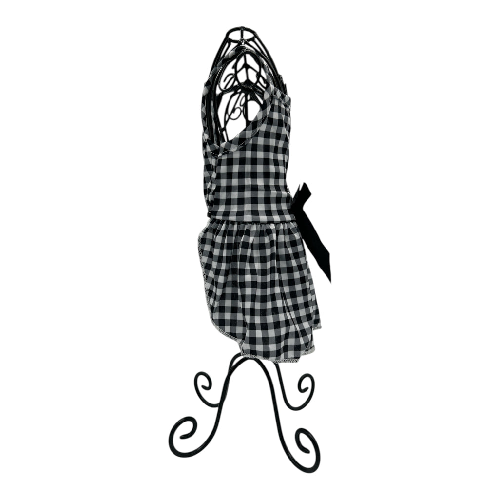 Black and white checkered cat dress on a decorative stand against a white background