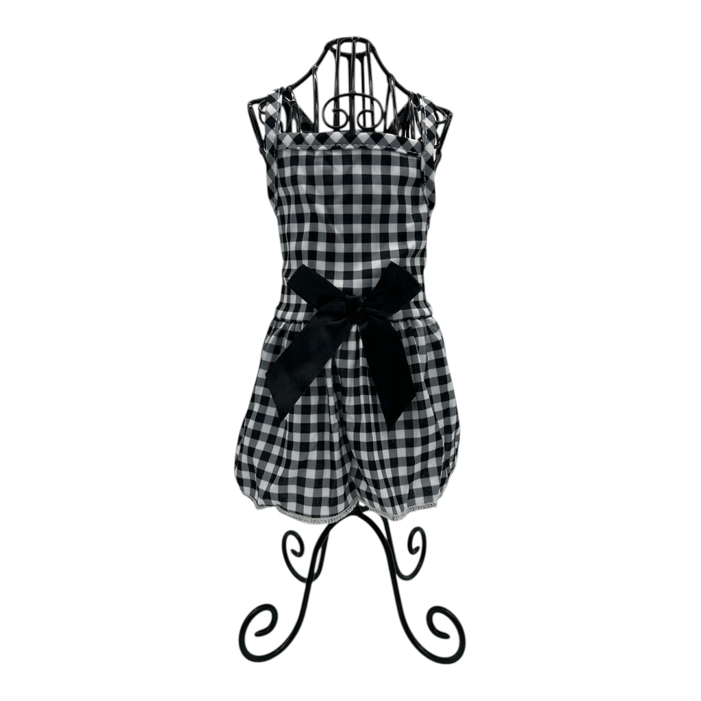 Black and white checkered cat dress with a bow on a decorative stand against a white background