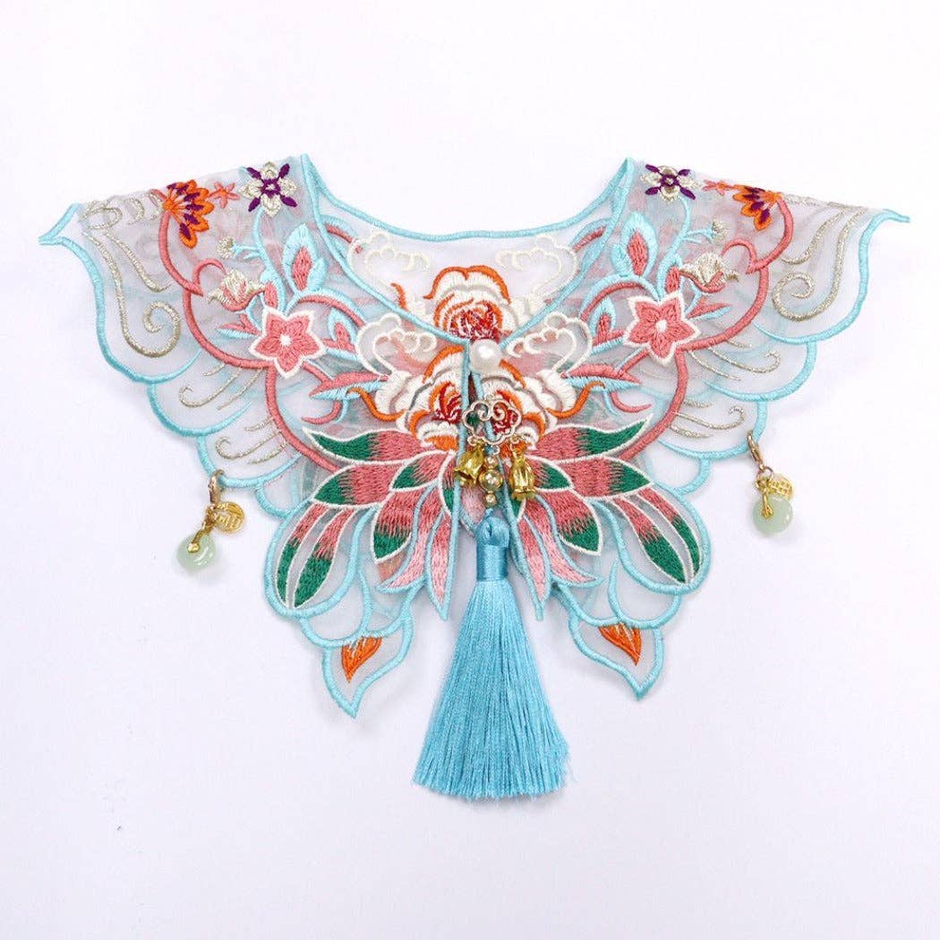 Decorative cat collar with floral patterns and tassels on a white background