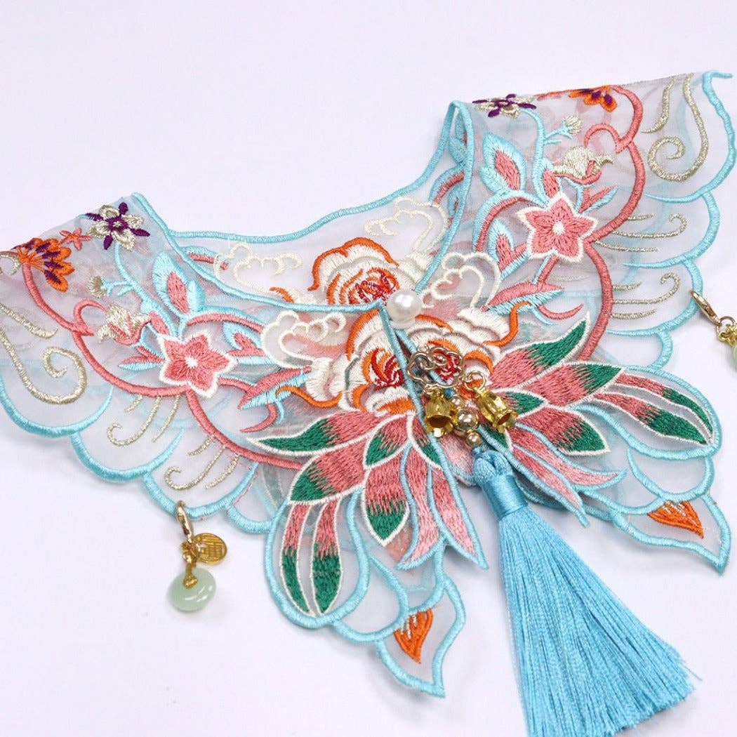 Decorative embroidered fabric with floral patterns and tassels cat collar on a white background