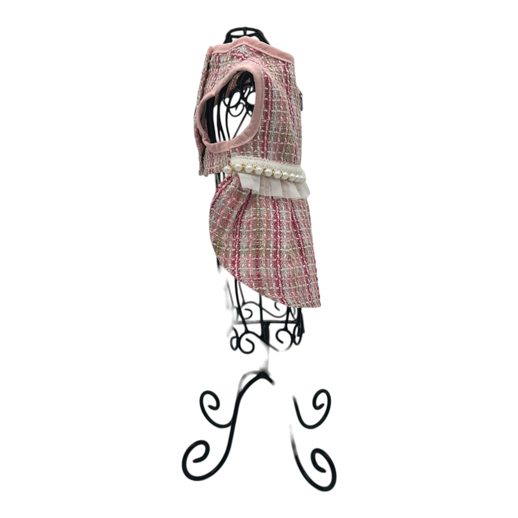 pink and white patterned cat dress on a decorative stand against a white background