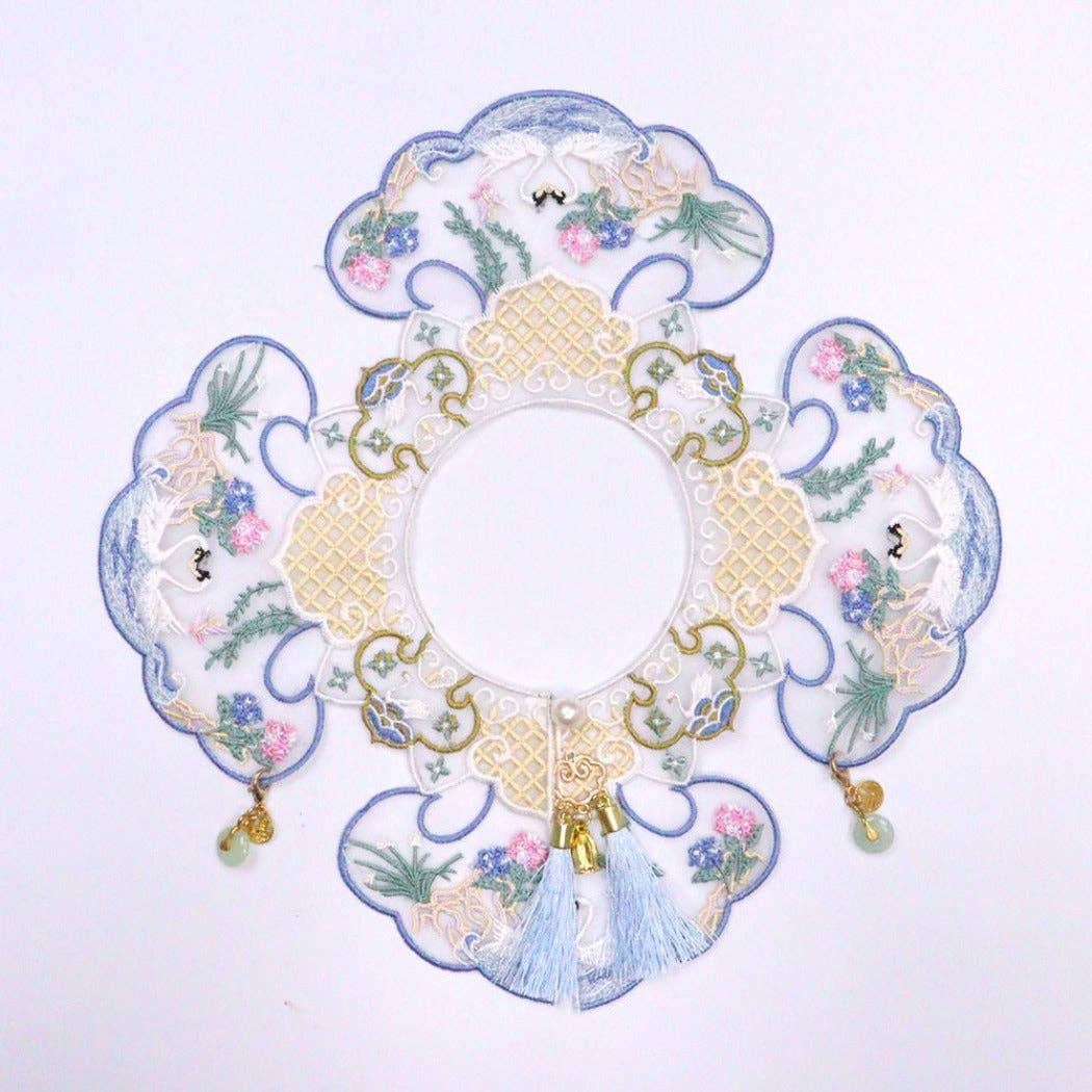 Decorative cat collar  with floral patterns and tassels on a white background