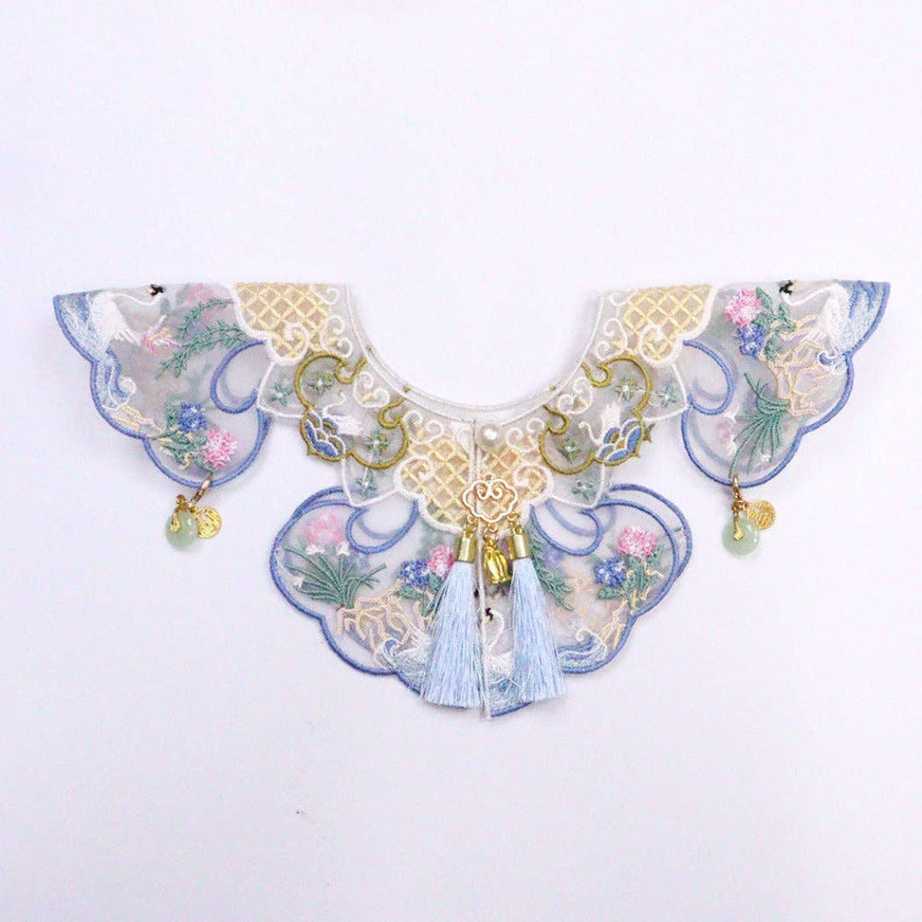 Decorative cat collar with floral patterns and tassels on a white background