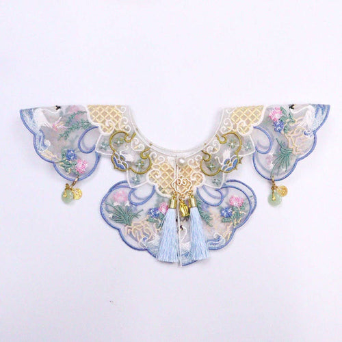 Decorative cat collar with floral patterns and tassels on a white background