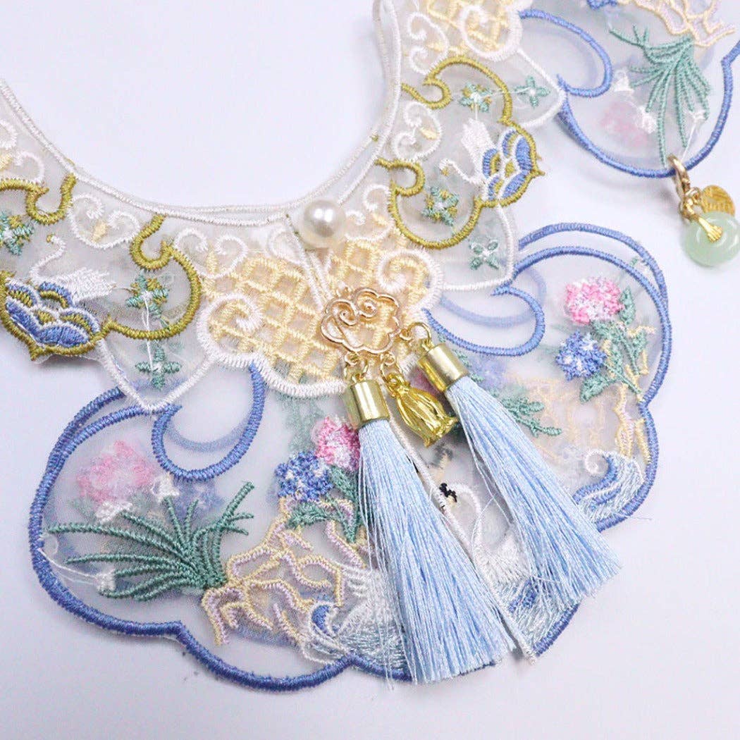 Decorative cat collar with intricate embroidery and tassels on a white background